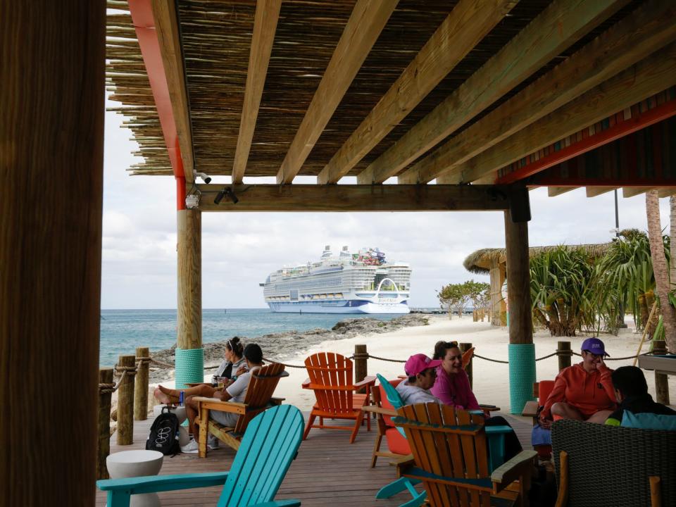 Icon of the Seas behind Royal Caribbean Perfect Day at CocoCay's Hideaway Beach's bar