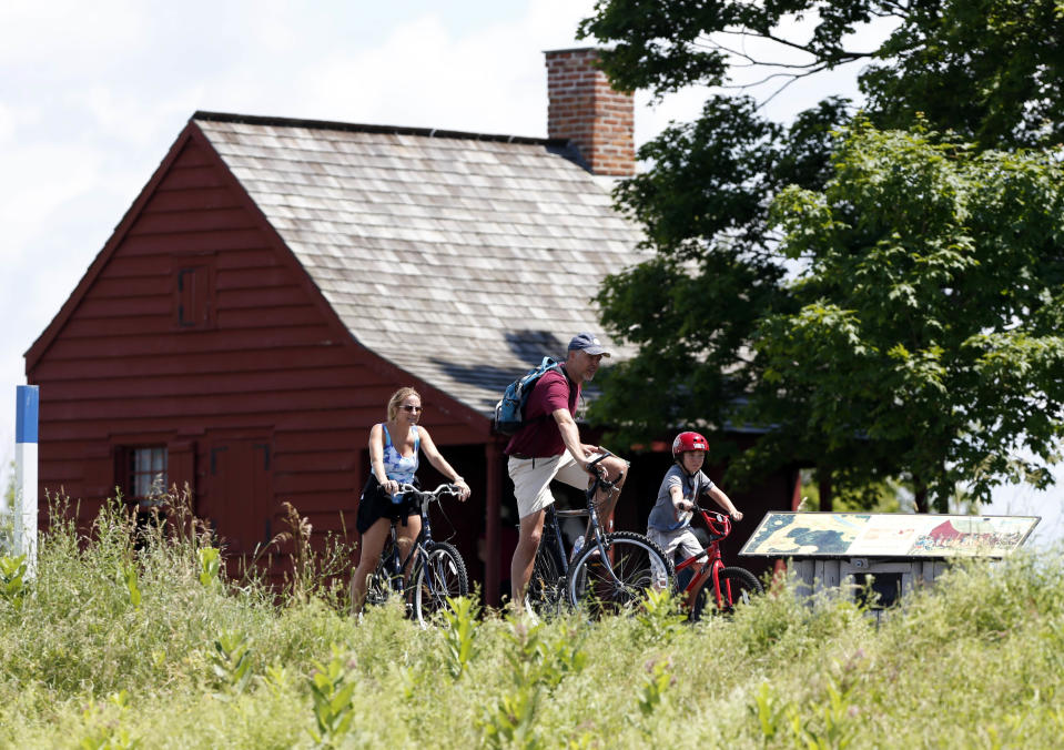 Casey Boynton, center, his wife Irene Boynton, left, and son Caz Boynton, of Toms River, N.J., stop near the Neilson Farm during a bike tour of Saratoga National Historical Park in Stillwater, N.Y., on Monday, July 2, 2012. The bike tours offer an opportunity to learn about a battle considered one of the most significant in history, while getting a not-too-strenuous workout at the same time. (AP Photo/Mike Groll)