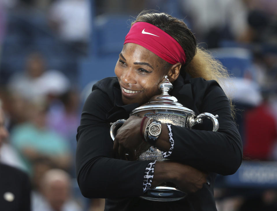 FILE - Serena Williams, of the United States, hugs the championship trophy after defeating Caroline Wozniacki, of Denmark, during the championship match of the 2014 U.S. Open tennis tournament, Sunday, Sept. 7, 2014, in New York. Saying “the countdown has begun,” 23-time Grand Slam champion Serena Williams said Tuesday, Aug. 9, 2022, she is ready to step away from tennis so she can turn her focus to having another child and her business interests, presaging the end of a career that transcended sports.(AP Photo/Mike Groll, File)