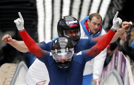 Russia's pilot Alexander Zubkov and Alexey Voevoda gesture after completing the final run of the men's two-man bobsleigh competition at the 2014 Sochi Winter Olympics February 17, 2014. REUTERS/Fabrizio Bensch