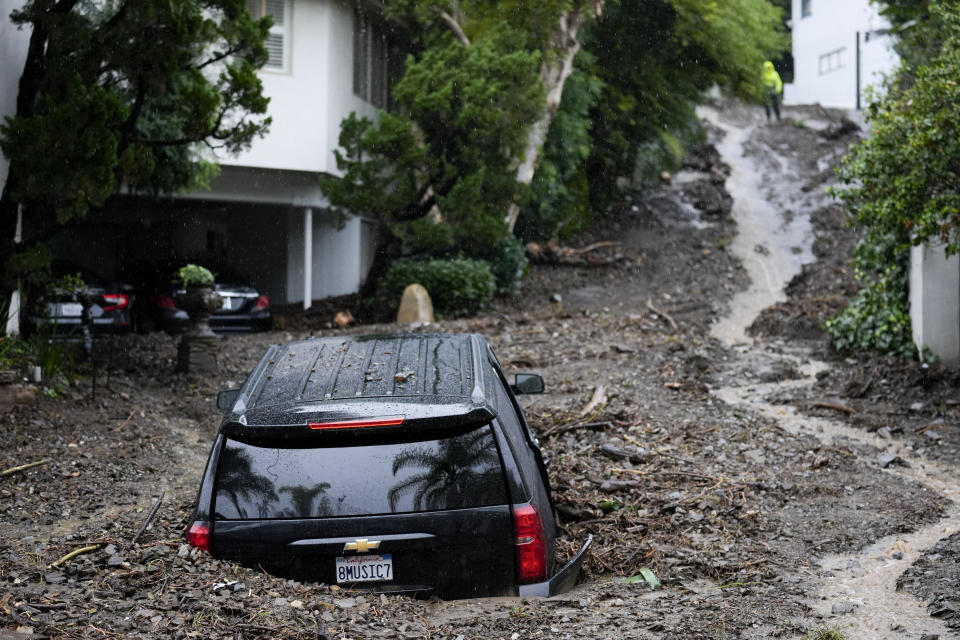 FILE - An SUV sits buried by a mudslide on Feb. 5, 2024, in the Beverly Crest area of Los Angeles. California's current rainy season got off to a slow start but has rebounded with recent storms that have covered mountains in snow and unleashed downpours, flooding and mudslides. The water content of the vital Sierra Nevada snowpack has topped 80% of normal to date while downtown Los Angeles has already received more than an entire year's average annual rainfall. (AP Photo/Marcio Jose Sanchez, File)