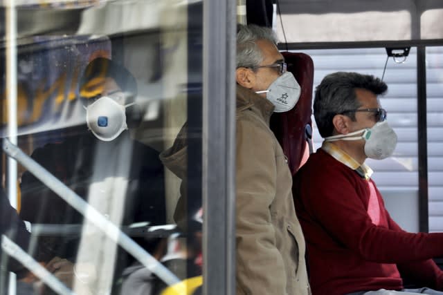 A bus driver and commuters wear masks to help protect against coronavirus in Tehran, Iran 