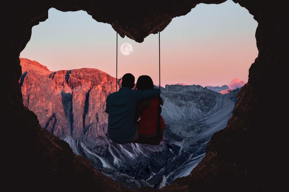 couple on swing contemplating the mountains in a romantic view with heart shape