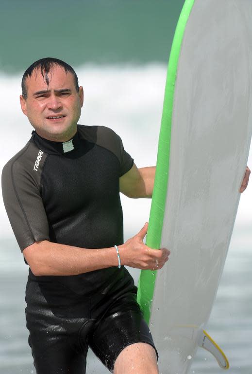 French Catholic priest Rene-Sebastien Fournie comes out of the water after surfing at Bidart, southwestern France, on September 3, 2013