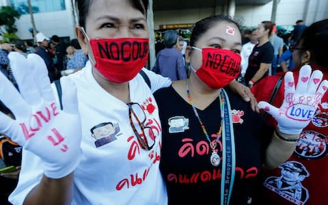 Supporters of former Thai Prime Minister Yingluck Shinawatra displays messages on their hands reading 'Love Pu,' Yingluck's Thai nickname, as they wear red masks reading 'NO COUP' in front of the Supreme Court's Criminal Division for Persons Holding Political Positions in Bangkok, Thailand, 27 September 2017 - Credit: EPA