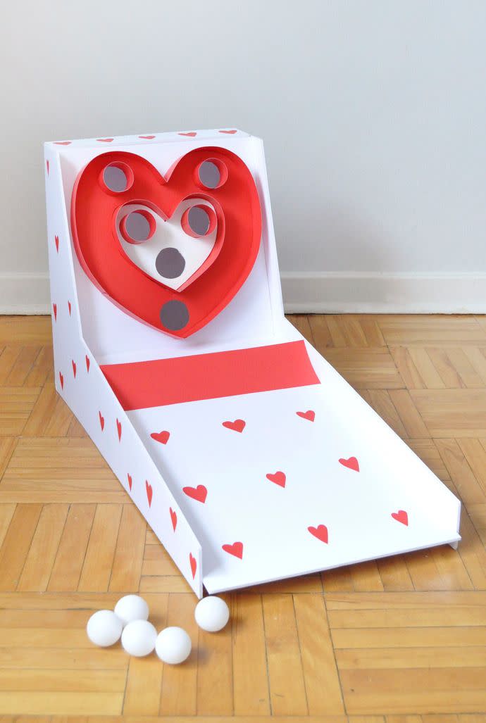 <p>You can recreate your kid's favorite arcade game at home (with a special Valentine's Day twist) — just build the main structure using a foam core, then have your kids help you decorate with lots of hearts before trying to score points with ping pong balls.</p><p><em><a href="https://www.handmadecharlotte.com/valentines-day-carnival-diy-skeeball/" rel="nofollow noopener" target="_blank" data-ylk="slk:Get the tutorial at Handmade Charlotte »;elm:context_link;itc:0" class="link ">Get the tutorial at Handmade Charlotte »</a></em><br></p>