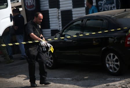 A federal police expert is seen near a site where an armed gang holds people hostage after they robbed a securities company at the Viracopos airpoart freight terminal, in Campinas