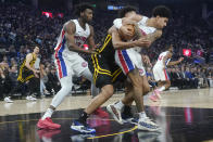 Detroit Pistons guard Killian Hayes, right, wrestles against Golden State Warriors forward Trayce Jackson-Davis, middle, for the ball during the first half of an NBA basketball game in San Francisco, Friday, Jan. 5, 2024. At left Pistoisns center James Wiseman. (AP Photo/Jeff Chiu)