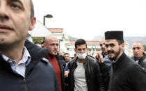 Serbian tennis player Novak Djokovic, center, wearing a face mask, arrives in the municipal building in Budva, Montenegro, Friday, Jan. 28, 2022. Djokovic arrived to receive a plaque declaring him an honorary citizen of the town. (AP Photo/Risto Bozovic)