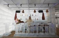 A waitress arranges ice cups on an ice counter during a photo opportunity at the Ice Palace in Shangri-La Hotel in the northern city of Harbin, Heilongjiang province January 6, 2014. The Ice Palace, which is built by ice bricks, is open annually from December to February and attracts visitors during the Harbin Ice and Snow Festival. The temperatures inside the ice building is maintained around -10 degrees Celsius and it consists of bar and hot pot restaurant. REUTERS/Kim Kyung-Hoon (CHINA - Tags: SOCIETY ENVIRONMENT TRAVEL)