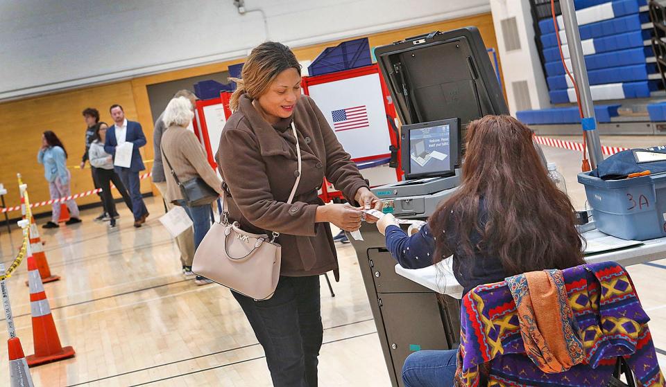 Adebisi Martins casts her ballot at East Middle School in Braintree on Tuesday.