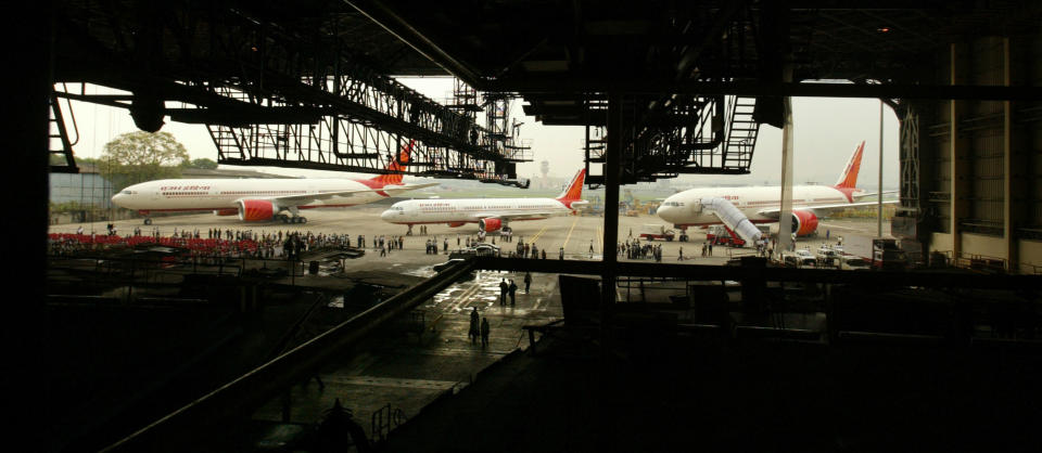 FILE- In this July 30, 2007, file photo, Air India's Boeing 777-200 LR aircraft, left and right, and Airbus A-321, center, stand parked during an event at the Chattrapati Shivaji International airport in Mumbai, India, Monday. Cash-starved Air India is putting its crew on a diet, changing their inflight menu to special low-fat meals. Dhananjay Kumar, the state-run airline's spokesman, said Wednesday, Sept. 18, 2019, that the objective is to provide healthy and cost-effective meals to crews on domestic and international flights. In 2009, the airline fired 10 air hostesses for being overweight after they failed to get back in shape three years after they were switched to ground crew jobs. (AP Photo/Gautam Singh, File)