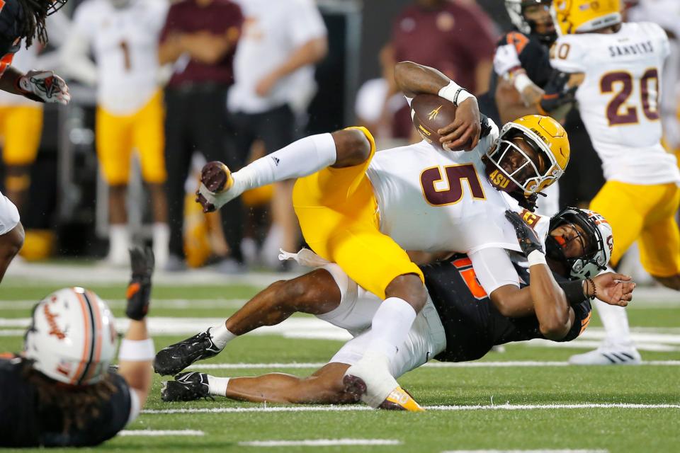 Sep 10, 2022; Stillwater, Oklahoma, USA; Oklahoma State Cowboys safety Sean Michael Flanagan (18) brings down Arizona State Sun Devils quarterback Emory Jones (5) during a football game at Boone Pickens Stadium. Mandatory Credit: Bryan Terry-USA TODAY Sports