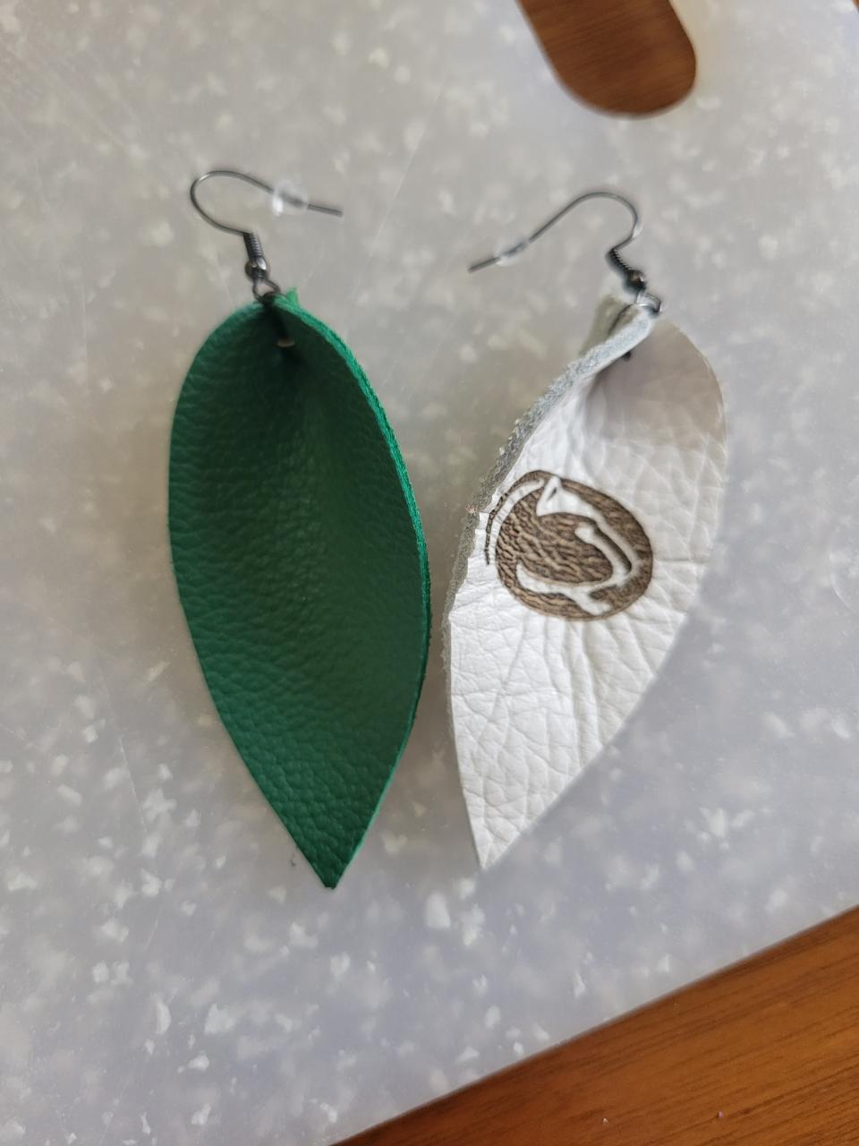 Katy Stechner of Franklin creates handmade leather earrings like this Greendale Panther set.