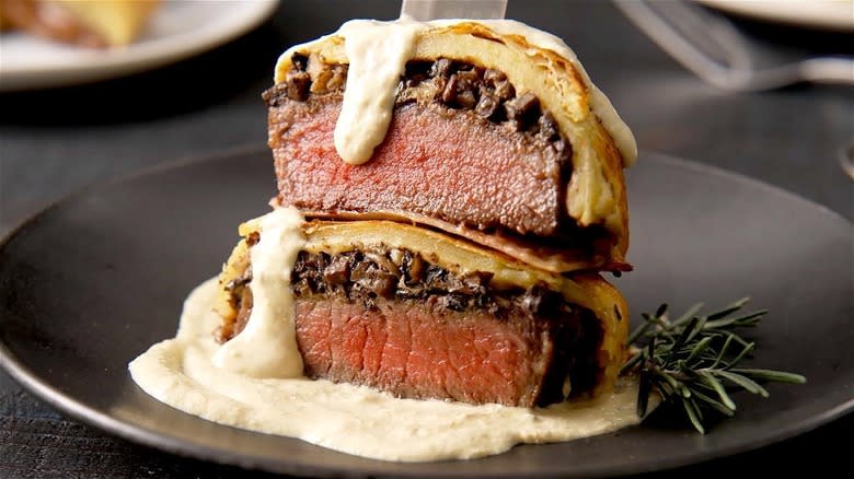 Two slices of beef Wellington with sauce