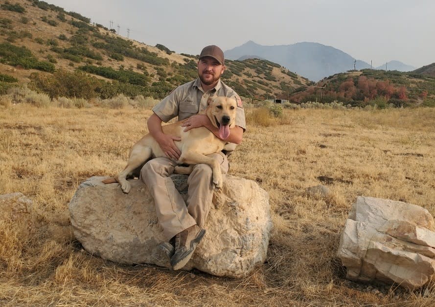 Conservation officer James Thomas sits with his K-9, Kip. (credit: Utah Division of Wildlife Resources)