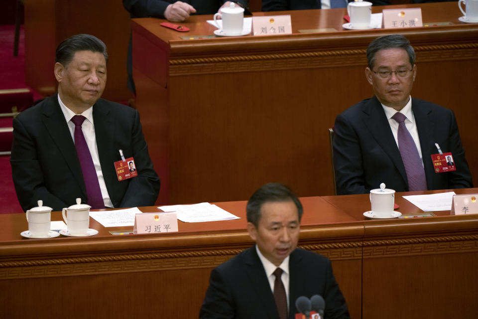 Chinese President Xi Jinping, left, and Li Qiang, right, attend a session of China's National People's Congress (NPC) at the Great Hall of the People in Beijing, Friday, March 10, 2023. Six men sit alongside Chinese leader Xi Jinping on the ruling Communist Party's all-powerful Politburo Standing Committee, handling major portfolios from propaganda to corruption fighting. (AP Photo/Mark Schiefelbein)