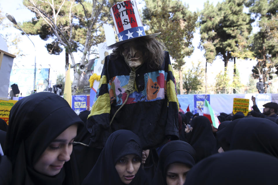 A demonstrator holds an effigy of US government icon "Uncle Sam" during a rally in front of the former U.S. Embassy in Tehran, Iran, on Sunday, Nov. 4, 2018, marking the 39th anniversary of the seizure of the embassy by militant Iranian students. Thousands of Iranians rallied in Tehran on Sunday to mark the anniversary as Washington restored all sanctions lifted under the nuclear deal. (AP Photo/Vahid Salemi)