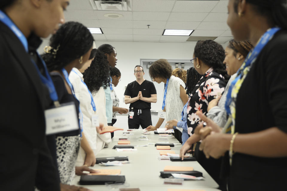 In this photo provided by the American Academy of Dermatology, Dr. Adam Friedman, a dermatologist, teaches AAD Pathways Career Prep students about common dermatologic procedures like biopsies and sutures during a hands-on bioskills workshop offered in collaboration with Nth Dimensions at the George Washington University Student Center in Washington on July 14, 2023. (Joshua Lee Reed/AAD via AP)