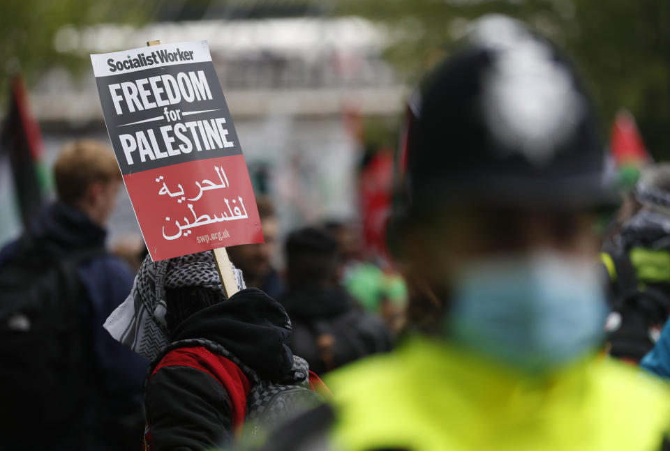 Protesters hold placards and banners in London, Saturday, May 22, 2021, as they take part in a rally supporting Palestinians. Egyptian mediators held talks Saturday to firm up an Israel-Hamas cease-fire as Palestinians in the Hamas-ruled Gaza Strip began to assess the damage from 11 days of intense Israeli bombardment. (AP Photo/Alastair Grant)