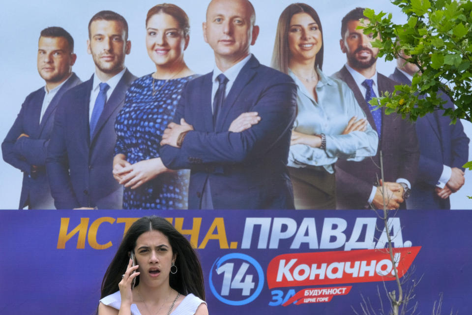 A woman walks past a pre-election billboard showing pro-Serbian and Russian coalition called "For the Future of Montenegro" in Podgorica, Montenegro, Friday, June 9, 2023. Montenegro is holding an early parliamentary election Sunday, a vote that could provide indications of whether the small NATO member in the Balkans will overcome the deep political divisions and instability that have hampered its route to joining the European Union. (AP Photo/Risto Bozovic)