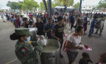 People line up to receive food at an army-provided soup kitchen for those affected by Hurricane Beryl in Tulum, Mexico, Friday, July 5, 2024. (AP Photo/Fernando Llano)