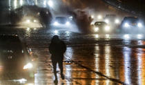 Motorists involved in a two car accident wait on the shoulder of the road of Westbound I-20 which made for treacherous driving with a lake of water that pooled across several lanes Wednesday morning, Nov. 30, 2022, in Atlanta. A vast storm system that spawned tornadoes across the South brought several hours of heavy rain to North Georgia on Wednesday morning, flooding interstates and making a mess of the commute. (John Spink/Atlanta Journal-Constitution via AP)