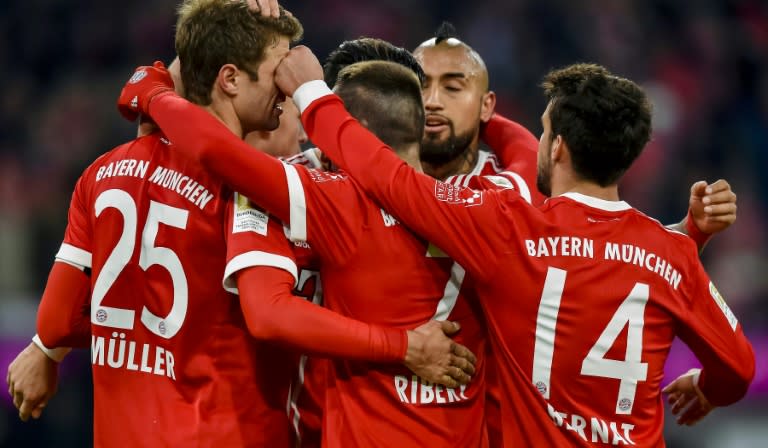 Bayern Munich's forward Thomas Mueller (L) is congratulated by teammates after he scored the team's 100th goal during a match against Werder Bremen on January 21, 2018