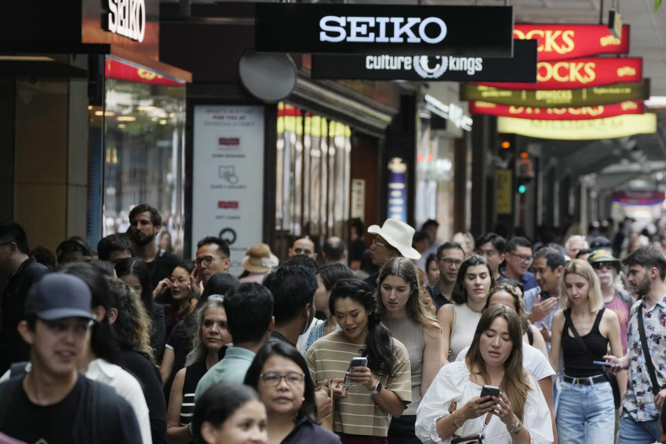 People walk past stores in central Sydney, Wednesday, Jan. 31, 2024. The Australian Bureau of Statistics said the latest consumers price index, or CPI, fell to 4.1%, down from 5.4% in September. (AP Photo/Rick Rycroft)