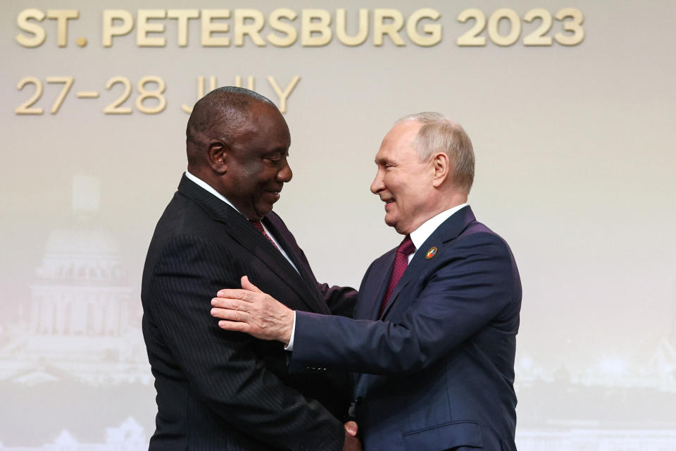 FILE - President of the Republic of South Africa Cyril Ramaphosa, left, and Russian President Vladimir Putin shake hands in St. Petersburg, Russia, Thursday, July 27, 2023. This word kuningi, "it's a lot," gained popularity among South Africans to express frustration over multiple controversies, such as record electricity outages and the government's close relationship with Russia. (Sergei Bobylev/TASS Host Photo Agency Pool Photo via AP, File)