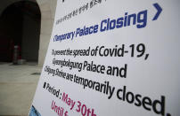 A sign of temporarily closure is displayed in front of Gwanghwamun, the main gate of the 14th-century Gyeongbok Palace, and one of South Korea's well-known landmarks, in Seoul, South Korea, Friday, June 19, 2020. (AP Photo/Lee Jin-man)