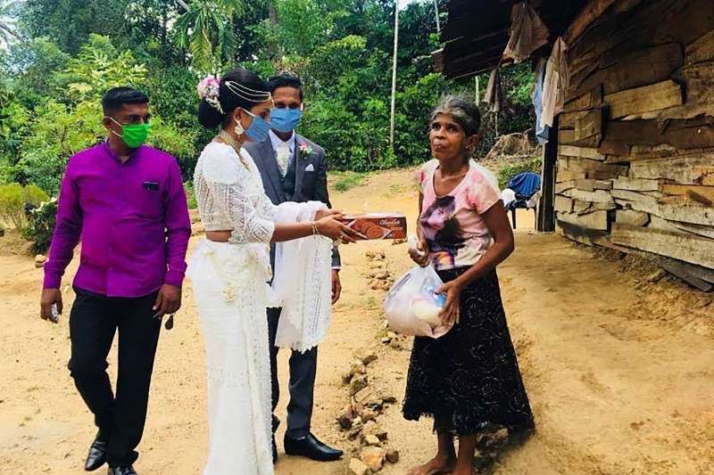 4月27日，斯里蘭卡的達沙那與帕瓦妮在登記結婚後，穿著禮服分送物資與禮物給當地的窮苦民眾（美聯社）