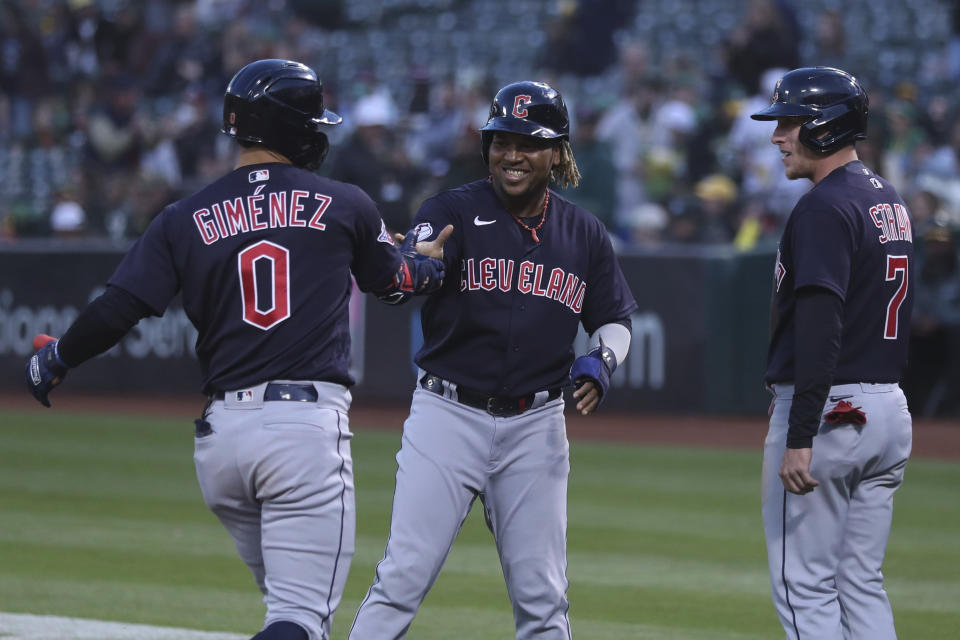 Cleveland Guardians' Andres Gimenez (0) is congratulated by Jose Ramirez, center, and Myles Straw, right, after hitting a grand slam against the Oakland Athletics during the third inning of a baseball game in Oakland, Calif., Friday, April 29, 2022. (AP Photo/Jed Jacobsohn)