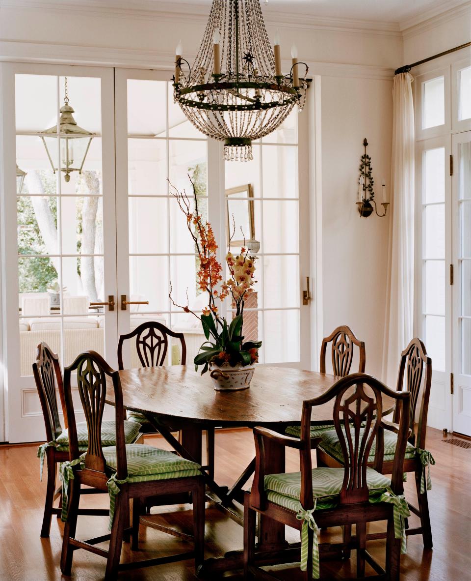 In the breakfast room, which opens to a terrace and loggia, an Italian Directoire–style chandelier crowns a 19th-century English table and 19th-century French pine dining chairs.