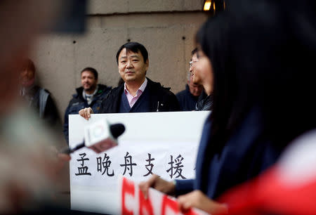 Terence Xu holds a sign in Chinese in support of Huawei CFO Meng Wanzhou outside of her B.C. Supreme Court bail hearing in Vancouver, British Columbia, Canada December 11, 2018. REUTERS/Lindsey Wasson