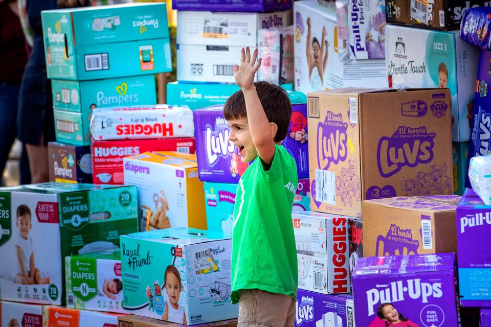 T.J. Moreno poses for a photo in front of a stack of diapers Thursday afternoon at the One More Child campus in Lakeland. For the second straight year, the 5-year-old led a campaign to collect and donate diapers.