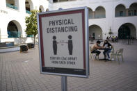 FILE - In this Wednesday, Sept. 2, 2020, file photo, people sit at tables at San Diego State University in San Diego. A coronavirus outbreak of more than 700 cases reported at San Diego State University has put all of San Diego County, with more than 3 million people, at risk of having to close indoor dining and shopping, many for a third time under California guidelines. (AP Photo/Gregory Bull, File)