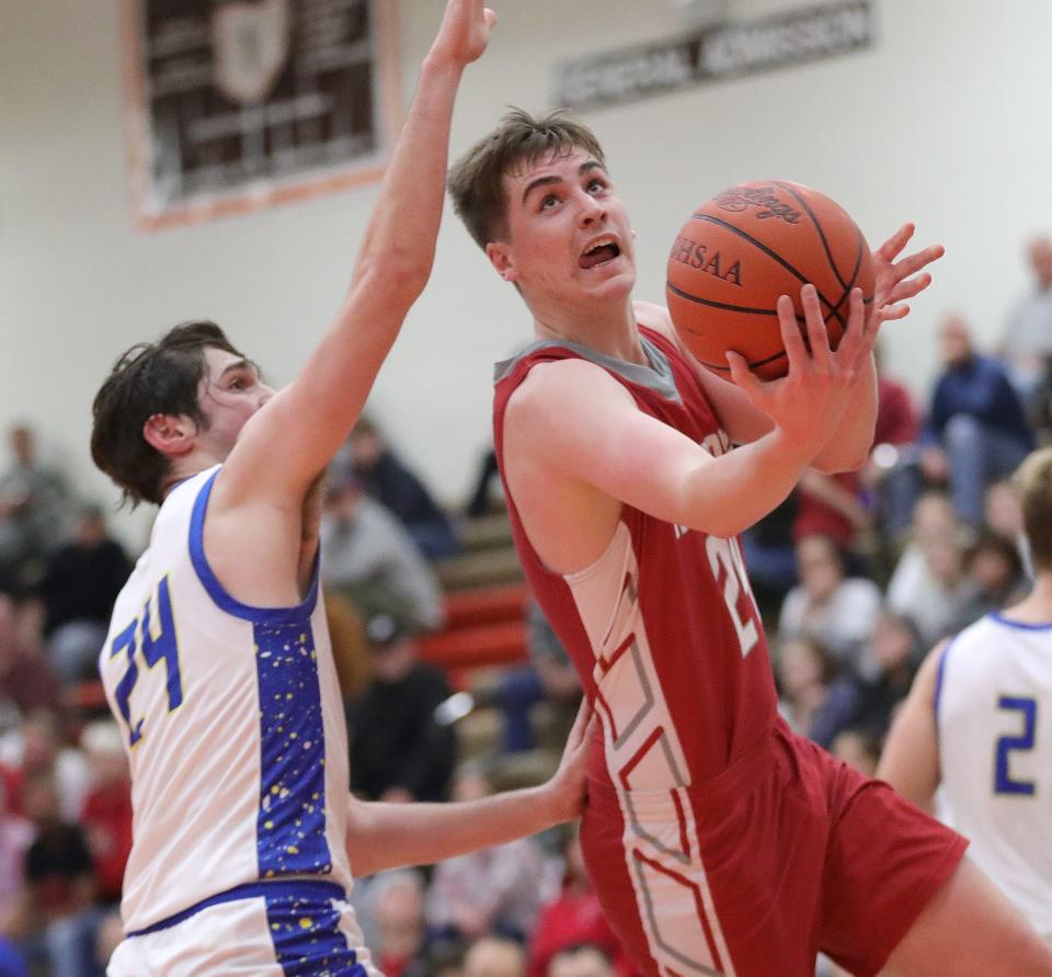 Minerva's Braydon Wood, right, puts up a shot defended by Maysville's Jordyn Watson during a district semifinal, Wednesday, March 6, 2024, at Claymont High School.