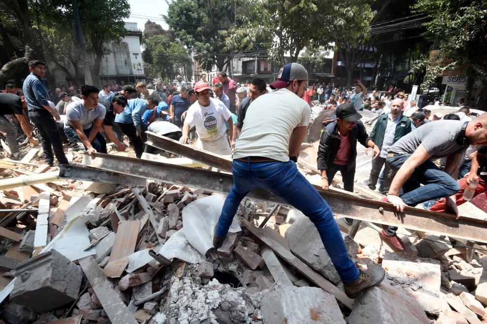 People remove debris of a collapsed building.