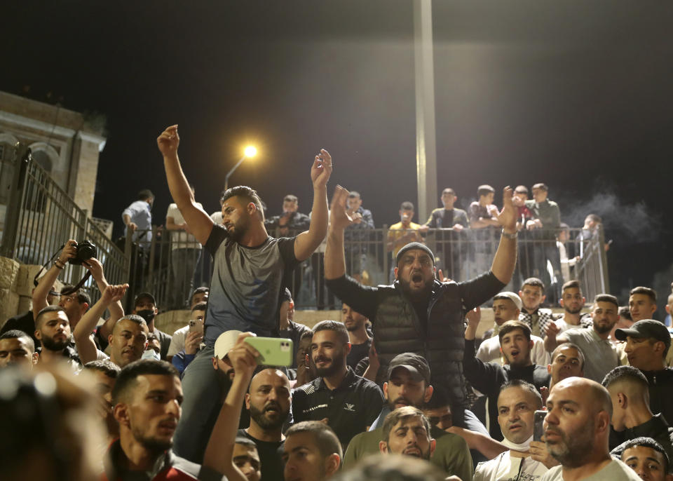 Palestinians celebrates after Israel's police removed barricades in a plaza outside of Jerusalem's Old City, Sunday, April 25, 2021. Israeli police late Sunday removed barricades outside Jerusalem's Old City that had prevented Muslims from meeting in a traditional gathering spot during the holy month of Ramadan. The barricades have sparked nightly clashes between Palestinian protesters and Israeli police, and their removal appeared to be aimed at easing the tensions. (AP Photo/Ariel Schalit)