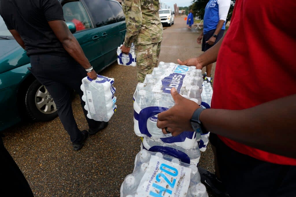 Volunteers distribute cases of water at a community/fraternal drive-thru water distribution site in Jackson, Miss., Sept. 7, 2022. (AP Photo/Rogelio V. Solis, File)