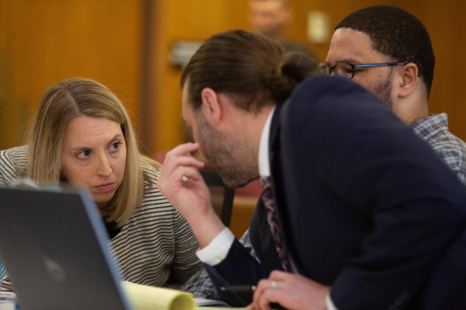 Defense attorneys Emily Barclay, left, and Peter Conley consult in January at a motion hearing for their client, Yanez Sanford, who sits between them and faces a capital murder charge. Barclay and Conley shared arguments regarding that motion at a hearing Monday in Shawnee County District Court, where a judge rejected it.