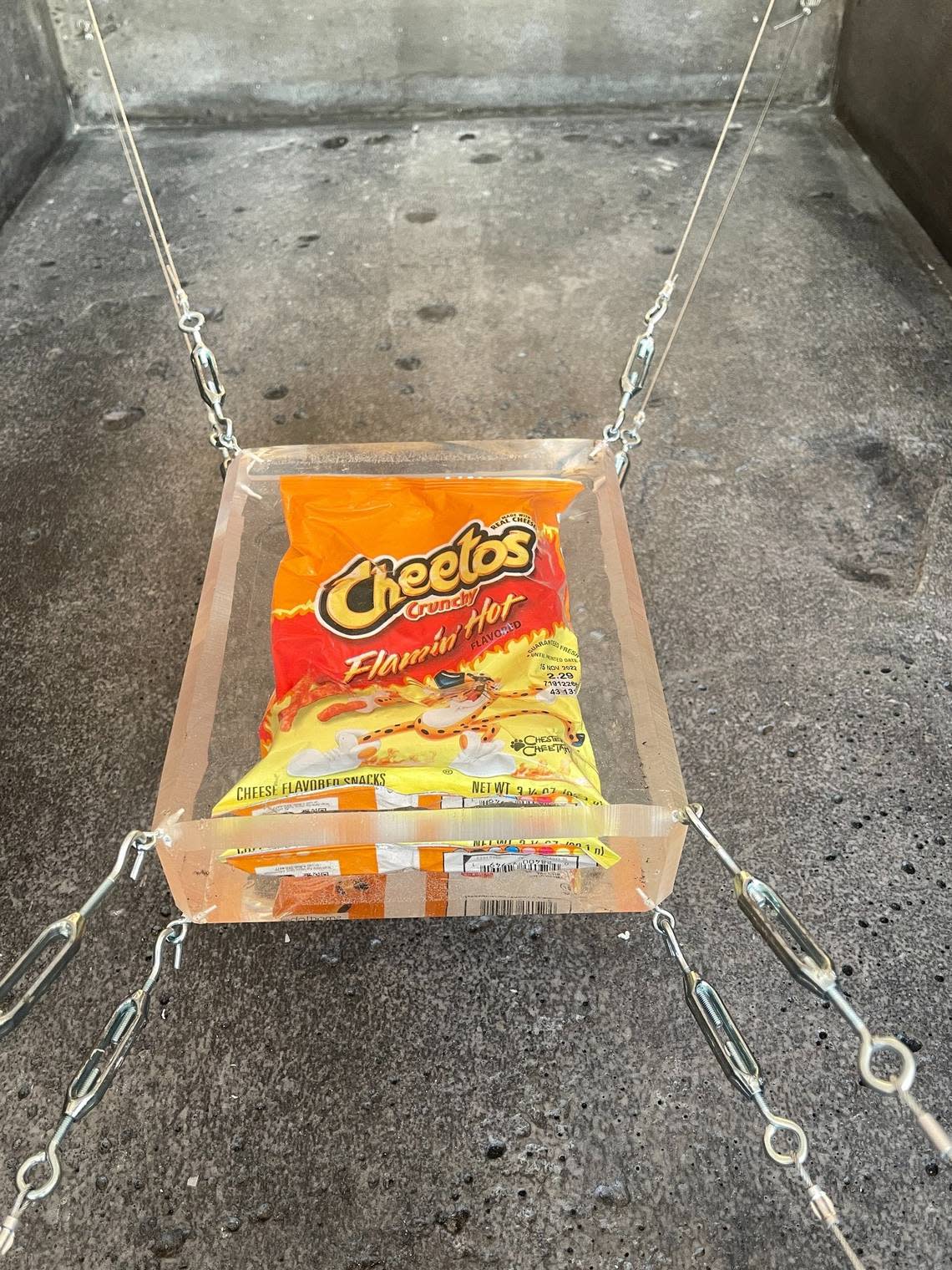 A 3,000 pound sarcophagus made by the artist Sunday Nobody holds only a suspended in resin bag of Flamin’ Hot Cheetos. 