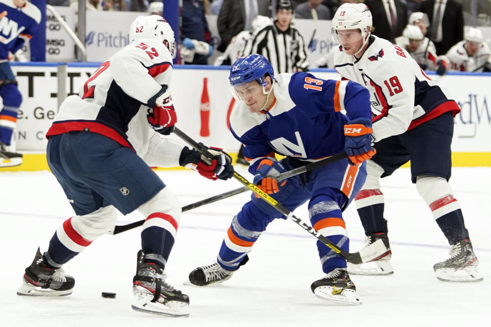 New York Islanders center Mathew Barzal (13) skates against Washington Capitals defenseman Matt Irwin (52) and center Nicklas Backstrom (19) during the second period of an NHL hockey game, Saturday, Jan. 15, 2022, in Elmont, N.Y. (AP Photo/Mary Altaffer)