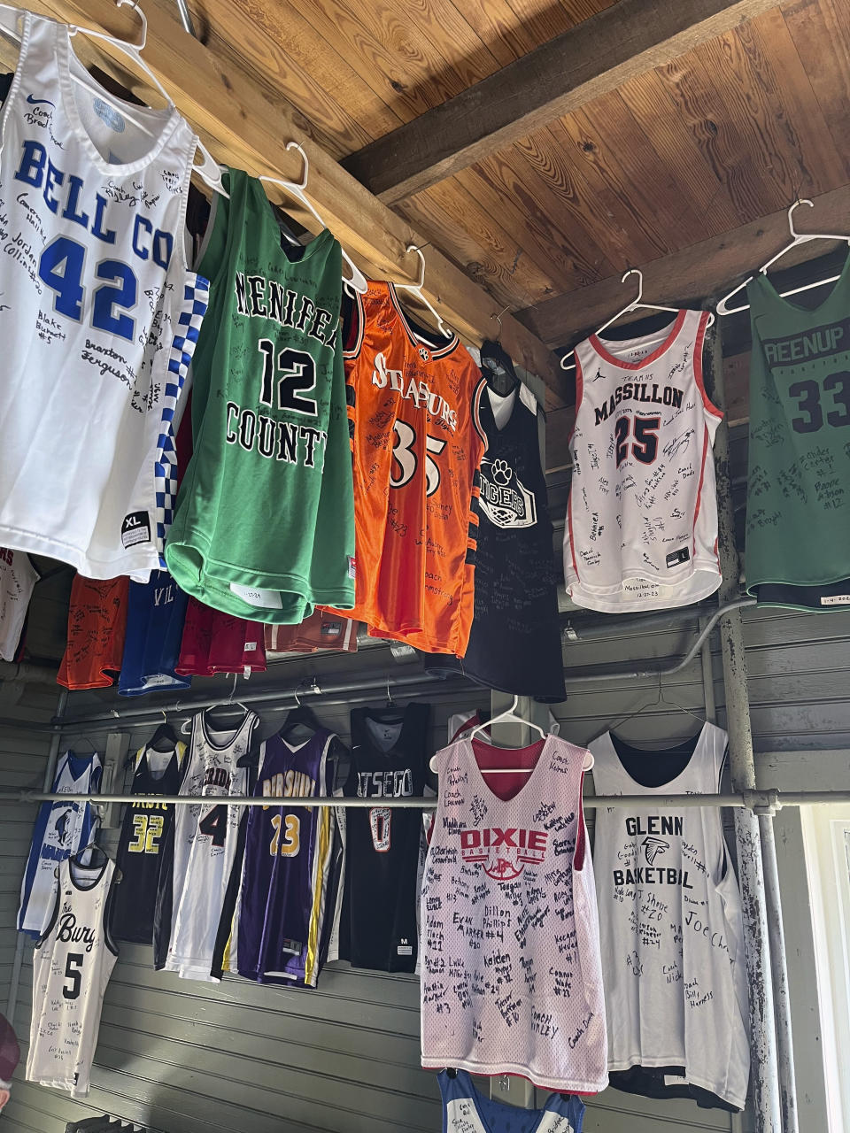 Signed jerseys left behind by high school teams hang at The Hoosier Gym in Knightstown, Ind., Monday, Feb. 19, 2024. The gym where many scenes from the movie “Hoosiers” was filmed in the mid-1980s plays host to dozens of high school games each year as fans still flock to the site. (AP Photo/Tim Reynolds)