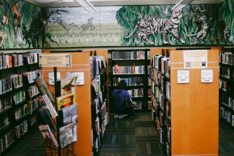 A woman peruses the books at Bartlett Public Library on Wednesday, March 20, 2024. The library, at 5884 Stage Road in Bartlett, will exit the Memphis Public Libraries system this summer.