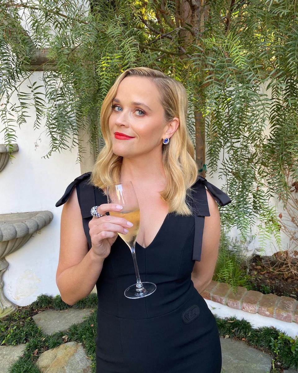 Reese Witherspoon wearing a black Louis Vuitton dress to celebrate the 2020 Emmys in her backyard