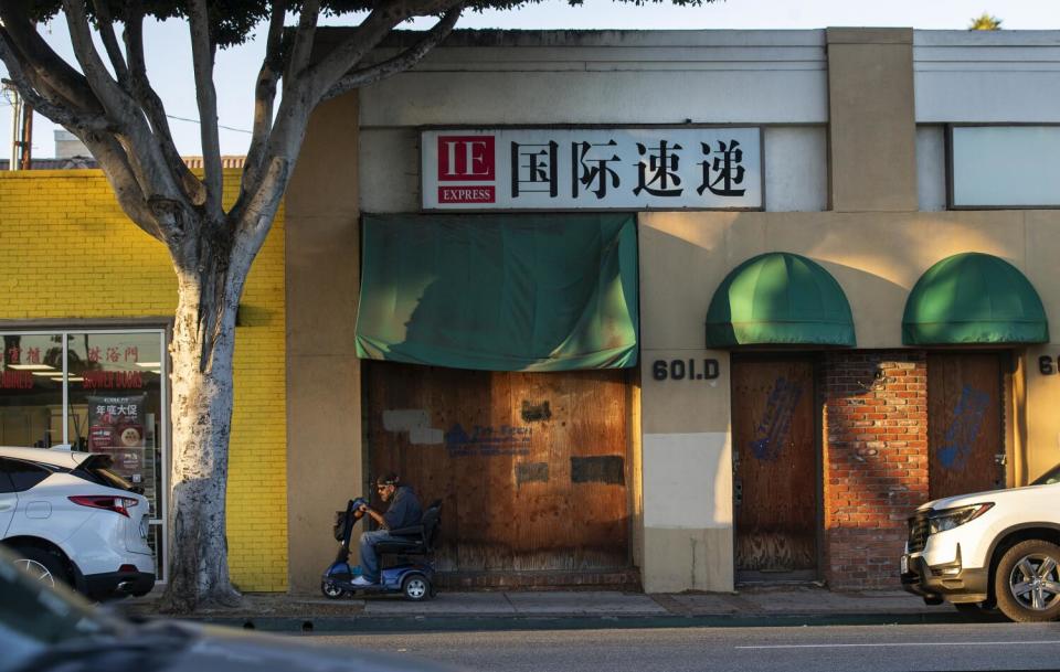 Photograph shows a boarded up and closed business on Garvey Ave.