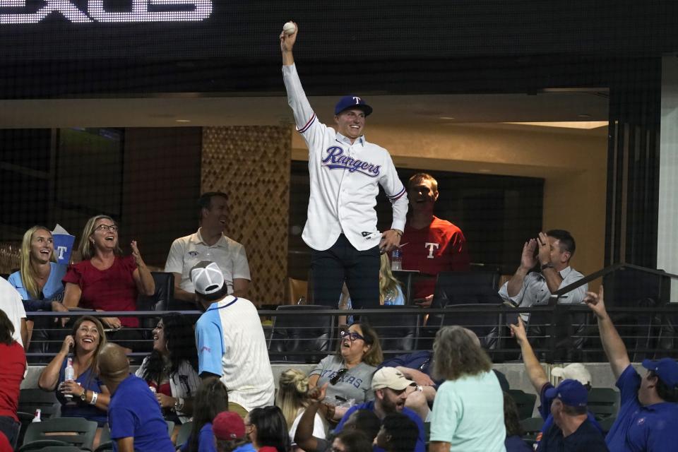 Newly signed Texas Rangers player Brock Porter celebrates after catching a foul ball during the fifth inning of the team's baseball game against the Chicago White Sox on Friday, Aug. 5, 2022, in Arlington, Texas. (AP Photo/Tony Gutierrez)