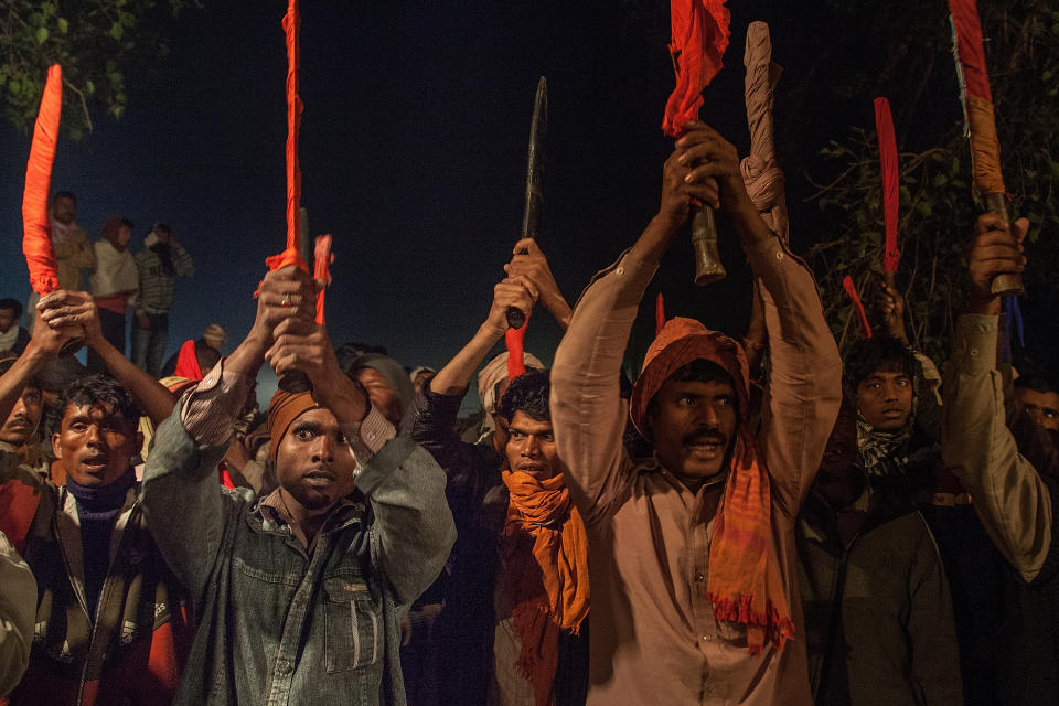 BARIYARPUR, NEPAL - NOVEMBER 28:  A group of devotees elevate as a blessing their traditional kukri knifes before the beginning of the animal sacrifices during the celebration of the Gadhimai festival on November 28, 2014 in Bariyarpur, Nepal. Over two million people attended this year's Gadhimai festival in Nepal's Bara Disctrict. Held every five years at the Gadhimai temple of Bariyarpur, the festival is the world's largest slaughter of animals, during which between thousands of water buffaloes, pigs, goats, chickens, rats and pigeons are slaughtered in order to please Gadhimai, the Goddess of Power. (Photo by Omar Havana/Getty Images)